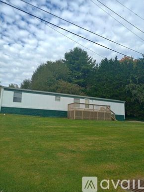 Bristol house for rent - A white building with a green roof and a wooden fence in front of it.