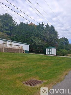 Bristol house for rent - A grassy field with a white building and a small shed.