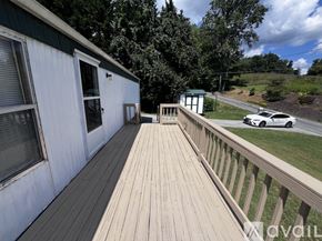 Bristol house for rent - A white house with a wooden deck and a car parked in the driveway.