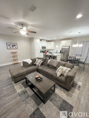Destin house for rent - A living room with a grey couch and a coffee table in the middle.