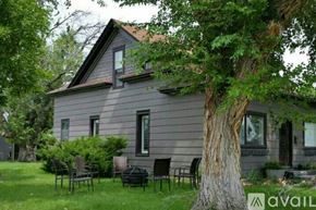 Cody house for rent - A house with a grey exterior and a tree in front of it.