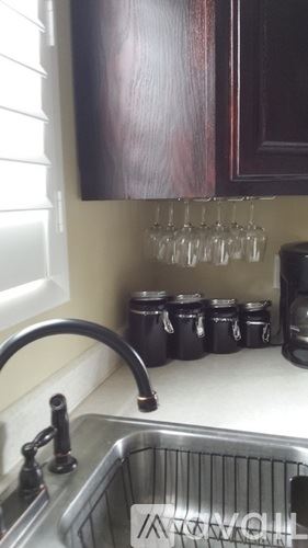 Cody house for rent - A kitchen sink with a metal faucet and a metal basket underneath it.