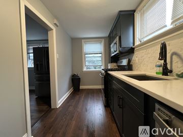 Delaware County house for rent - A kitchen with black cabinets and a wooden floor.