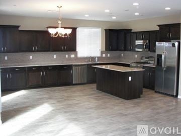 Henderson house for rent - A kitchen with dark wood cabinets and a center island.
