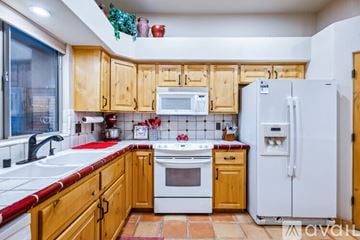 Lake Havasu City house for rent - A kitchen with wooden cabinets and a white refrigerator.