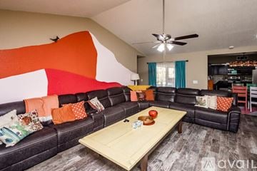 Lake Havasu City house for rent - A living room with a black couch and a wooden coffee table.