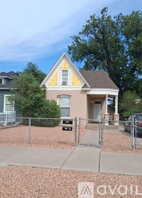 Pueblo house for rent - A small house with a fence in front of it.