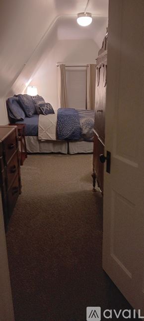Pueblo house for rent - A bedroom with a bed and a carpeted floor.