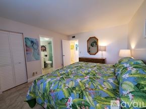 Jupiter condo for rent - A bedroom with a bed covered in a floral print bedspread.