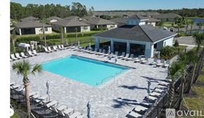 Port Charlotte house for rent - A large swimming pool surrounded by lounge chairs and umbrellas.