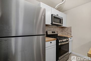 Berkeley apartment for rent - A kitchen with a stainless steel refrigerator and a microwave above the stove.
