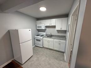 Louisville apartment for rent - A kitchen with white appliances and cabinets.