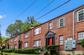 Louisville apartment for rent - A red brick building with a black door and windows.