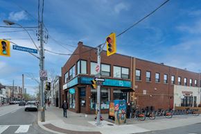 Toronto apartment for rent - A street view with a traffic light and a building with a blue sign.