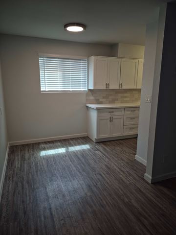 Phoenix apartment for rent - A kitchen with white cabinets and a window with blinds.