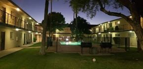 Phoenix apartment for rent - A building with a pool in the courtyard at night.