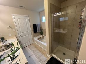 San Antonio house for rent - A bathroom with a white door and a glass shower stall.