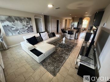 San Antonio house for rent - A modern living room with a large white sofa and a grey rug.
