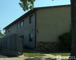 La Crosse apartment for rent - A building with a stone wall and a brown roof.