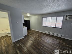 La Crosse apartment for rent - A room with wooden floors and a window with blinds.