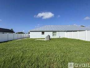 Sebring house for rent - A large white building with a grey roof is surrounded by a grassy field.