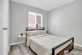 Indio apartment for rent - A bedroom with a large bed and a window overlooking a building.