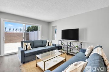 Indio apartment for rent - A living room with a grey couch and a glass coffee table.