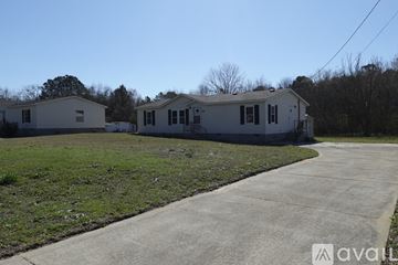 Kathleen house for rent - A kitchen with a black refrigerator and cabinets.