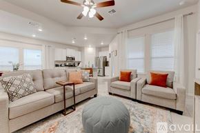 Temple house for rent - A living room with a beige sofa, a grey ottoman, and a ceiling fan.