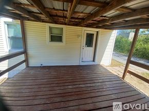 Saint Ann house for rent - A wooden deck with a door and a window.