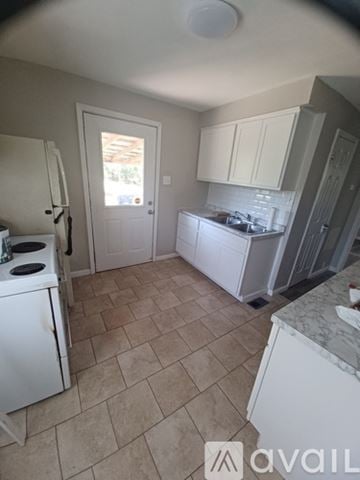 Saint Ann house for rent - A kitchen with a white stove and cabinets.