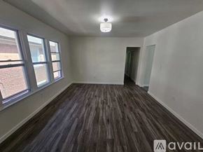 Detroit house for rent - A room with wooden flooring and a window overlooking a brick building.