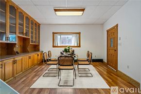 Pittsburgh house for rent - A red brick house with a grey roof and a white window.