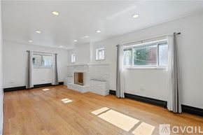 Pittsburgh house for rent - A spacious living room with a fireplace and hardwood floors.