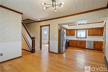 Pittsburgh house for rent - A kitchen with wooden cabinets and a refrigerator in the middle of the room.