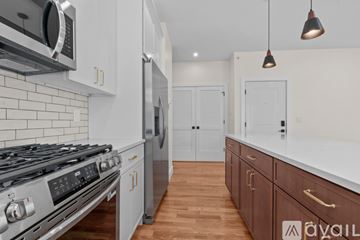 Newark apartment for rent - A modern kitchen with a stove top oven and a microwave above it.