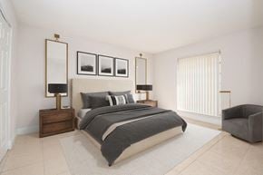 Kendall apartment for rent - a bedroom with white walls and a large window and a bed