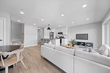 Ottawa apartment for rent - A modern living room with a white couch and a wooden dining table.