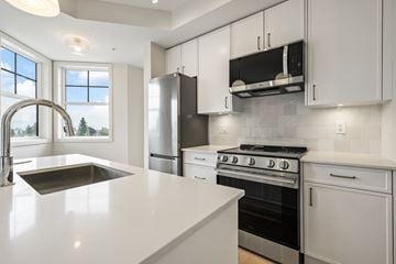 Chilliwack apartment for rent - A modern kitchen with white cabinets and stainless steel appliances.