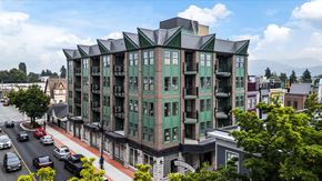 Chilliwack apartment for rent - A large green building with a black roof sits on a street corner.