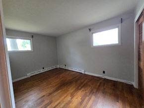 Michigan City house for rent - A room with wooden floors and two windows.