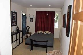 Santa Barbara house for rent - A bedroom with a bed, chair, and pictures on the wall.
