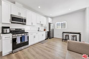Los Angeles apartment for rent - A kitchen with white cabinets and a black stove top oven.