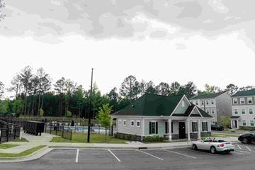 Morrisville house for rent - A parking lot with a building and a car.
