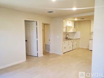 San Antonio apartment for rent - A kitchen area with white cabinets and a white door.