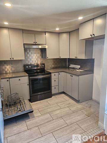 Yorba Linda apartment for rent - A kitchen with white cabinets and a black stove top oven.