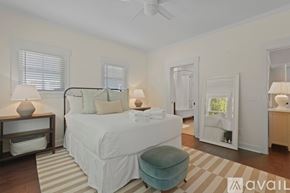 Savannah house for rent - A bedroom with a large bed and a striped rug.
