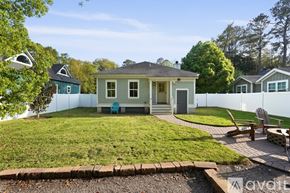 Savannah house for rent - A house with a blue chair sits in a grassy backyard.