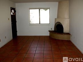 Santa Fe apartment for rent - A room with a red tile floor and a wood-burning stove.