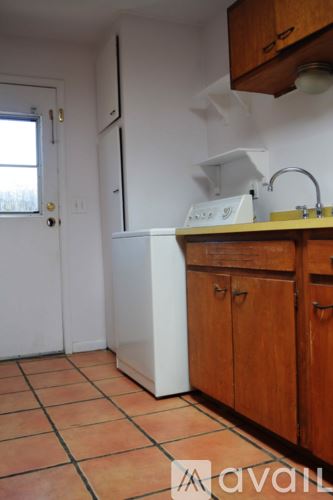 Santa Fe apartment for rent - A kitchen with tile flooring and wooden cabinets.